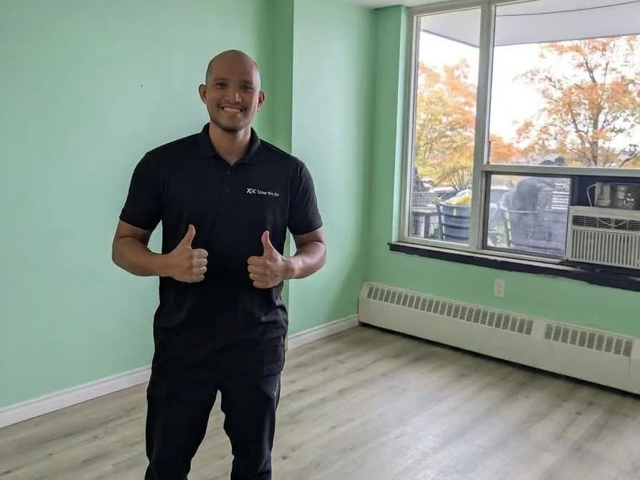 Dan from the Clear We Go team giving a thumbs up in the empty, swept living room